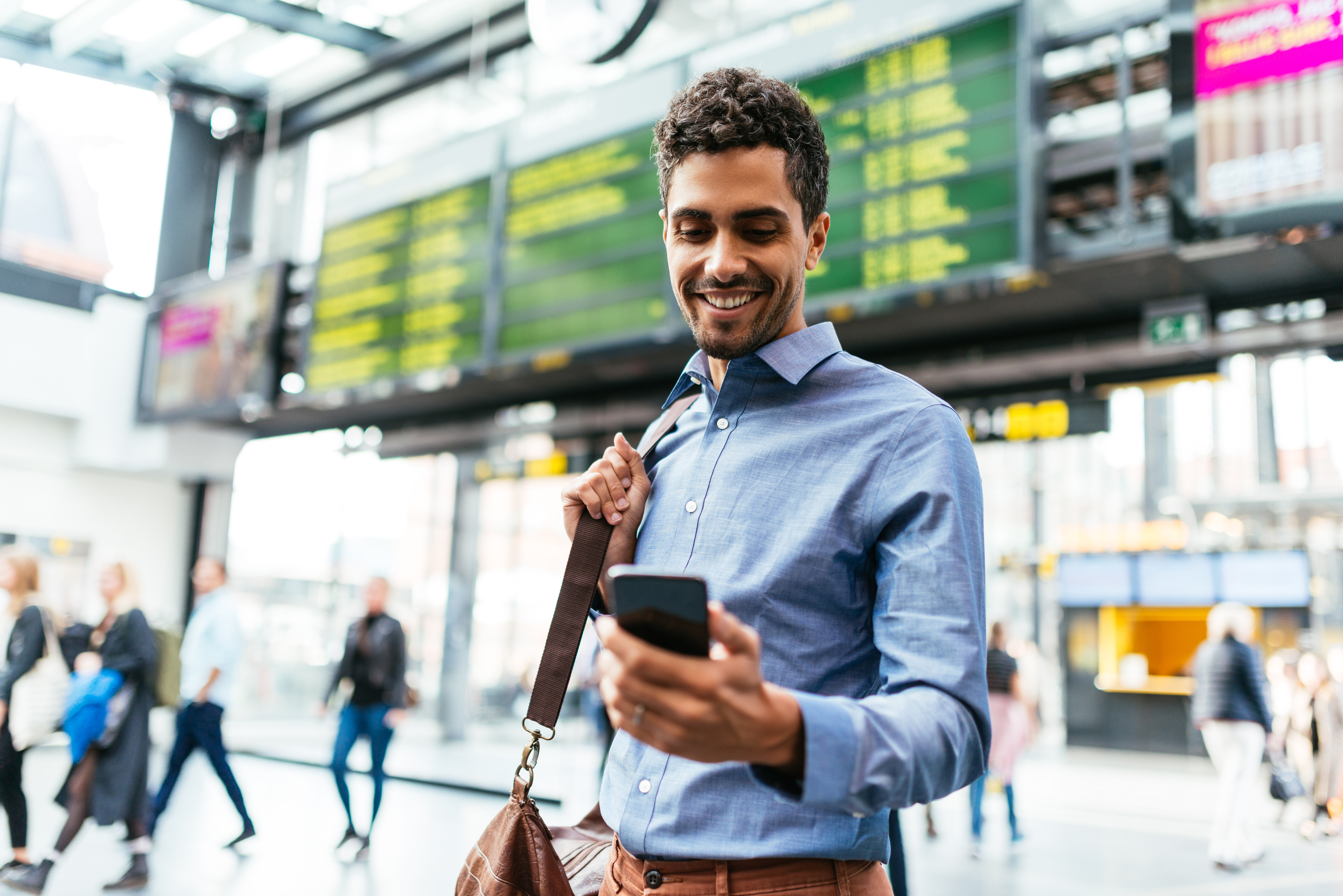 person looking at phone in airport 