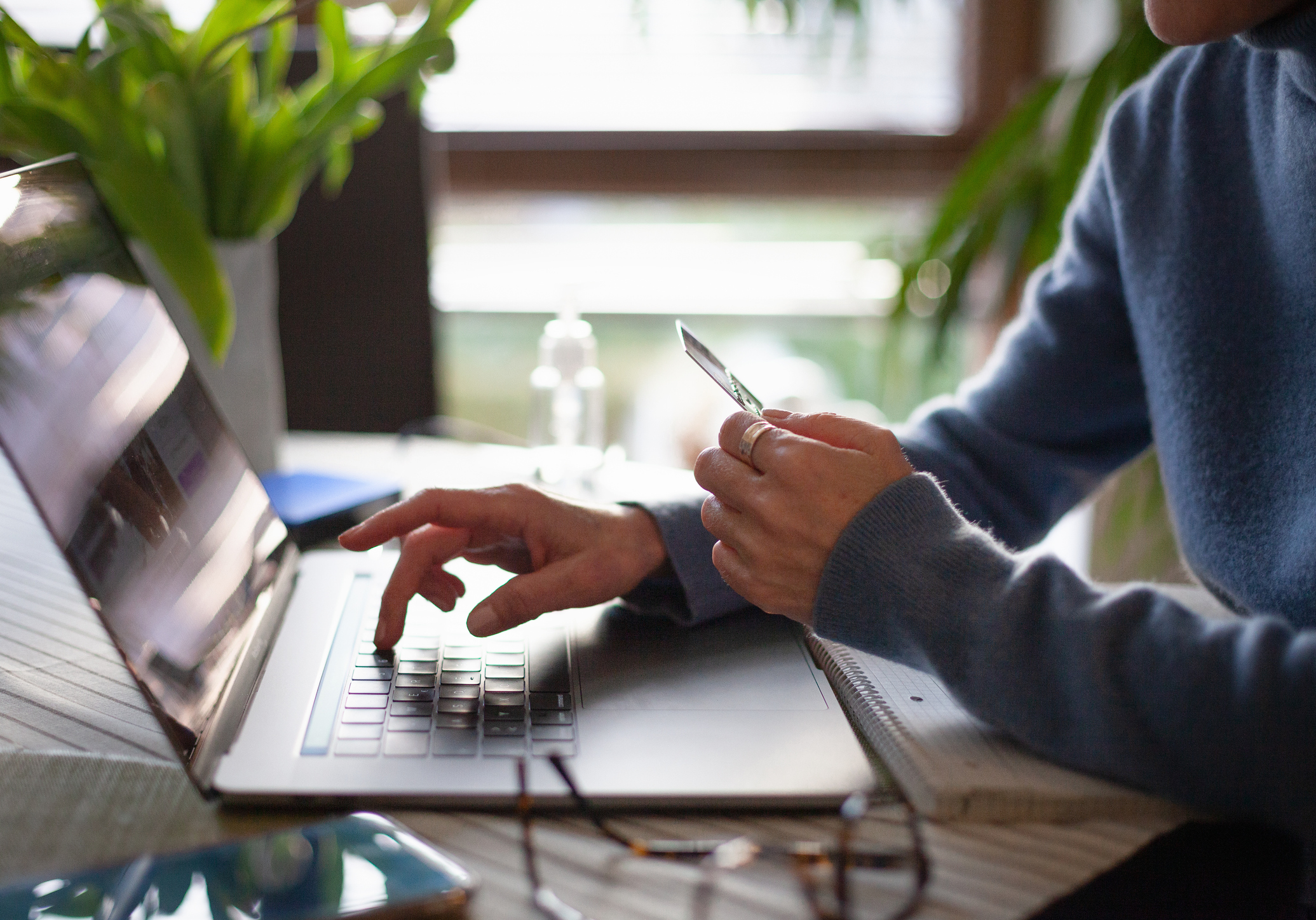 Person on laptop holding credit card