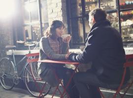 woman and man sitting outside at red table