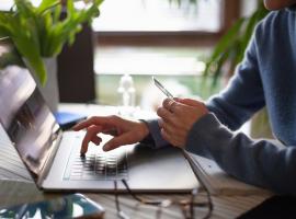 Person on laptop holding credit card