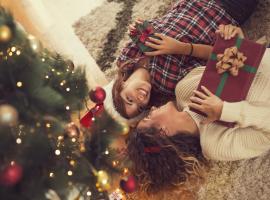 two people holding gifts under tree